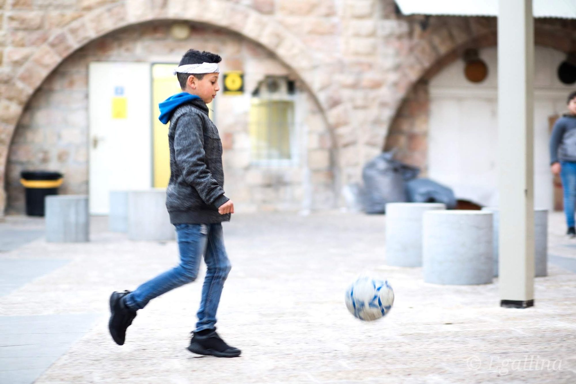 Photo of a boy kicking a soccer ball in Jerusalem
