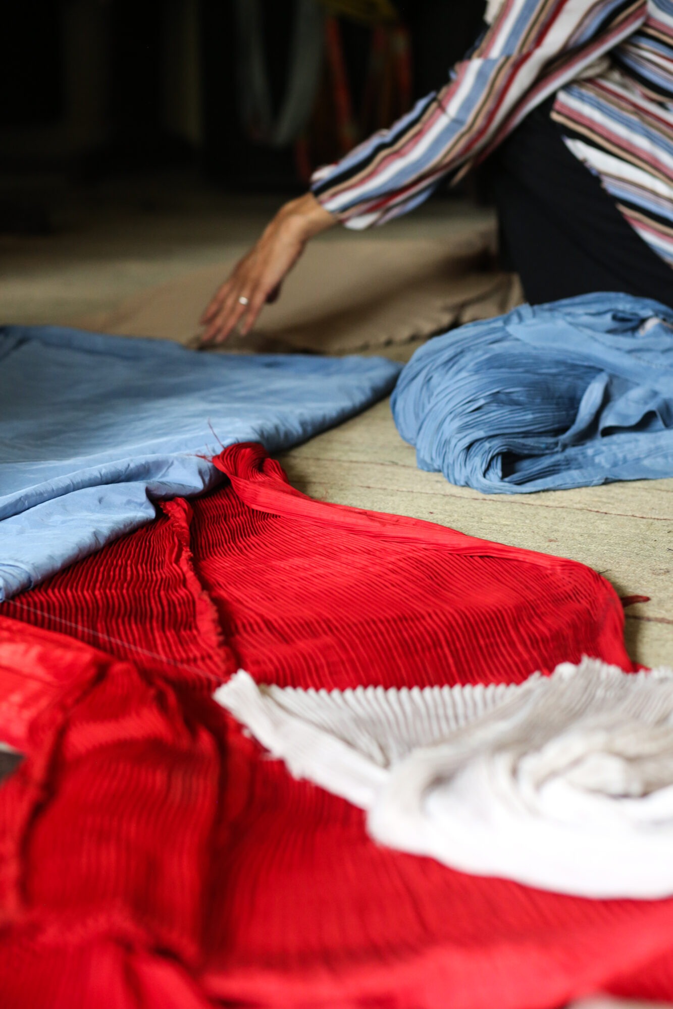 Photo of Afghani clothing designer working on the floor