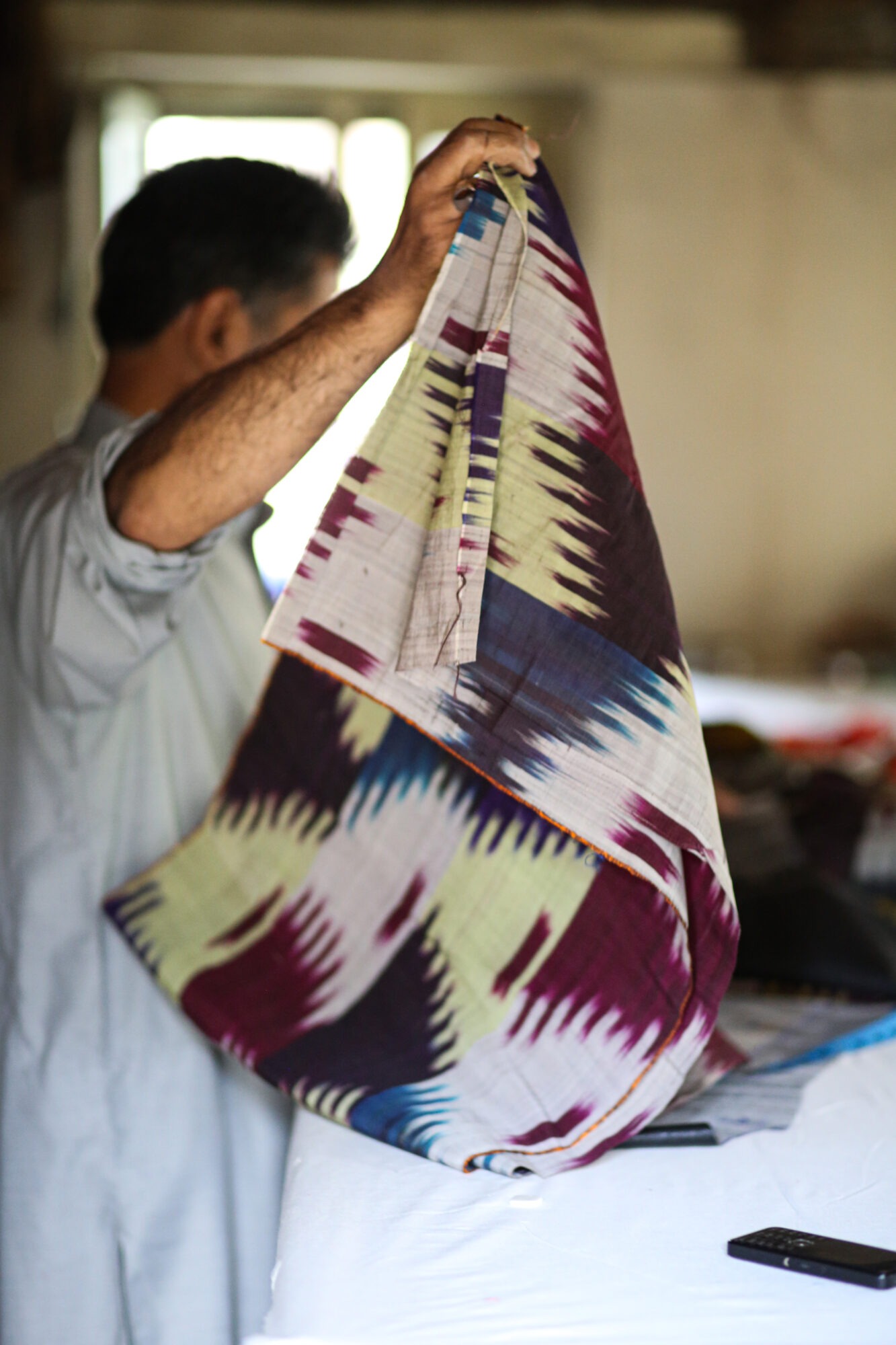 Photo of an Afghani man holding fabric