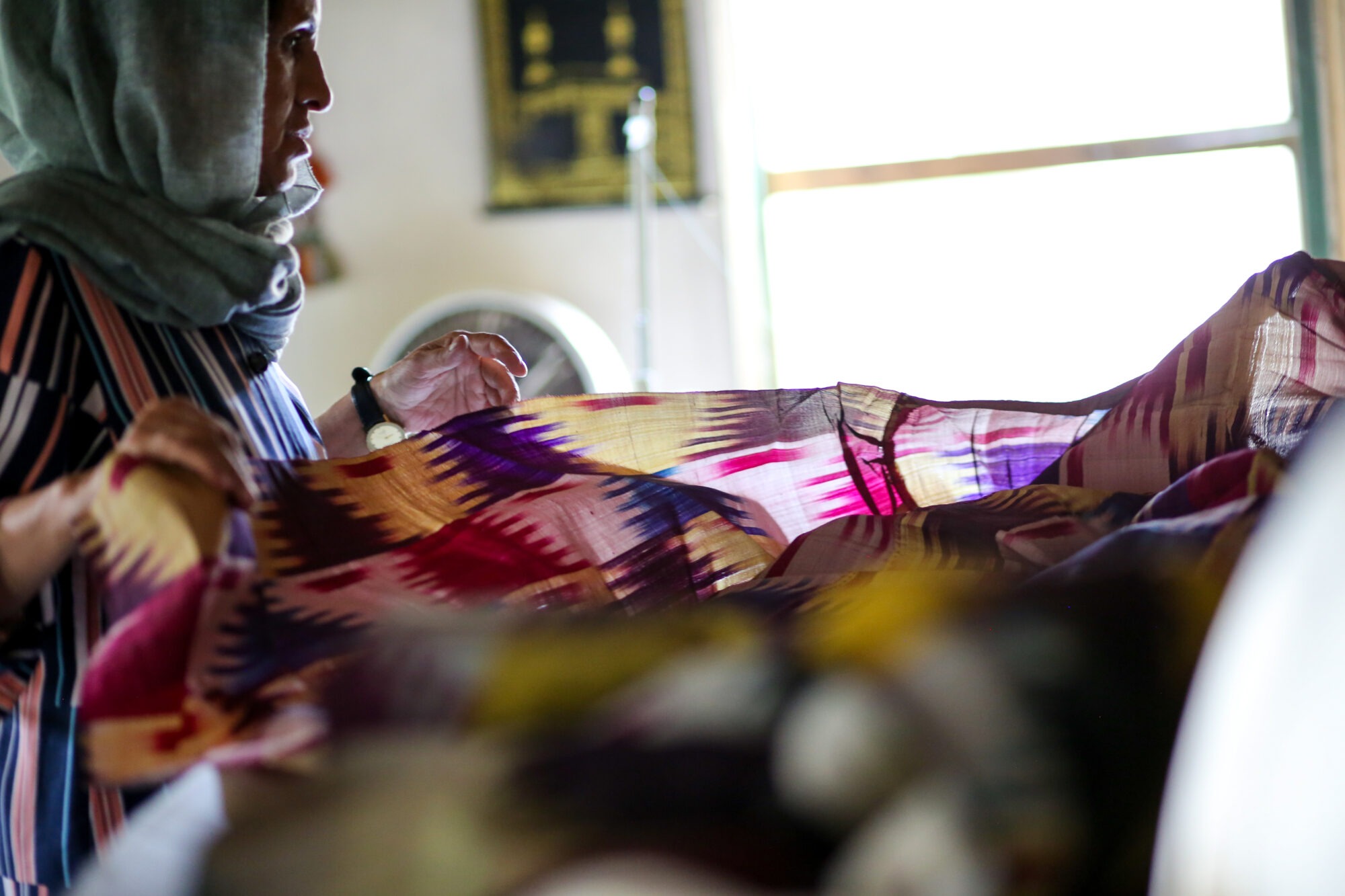 Photo of an Afghani woman and light shining through ornate fabric